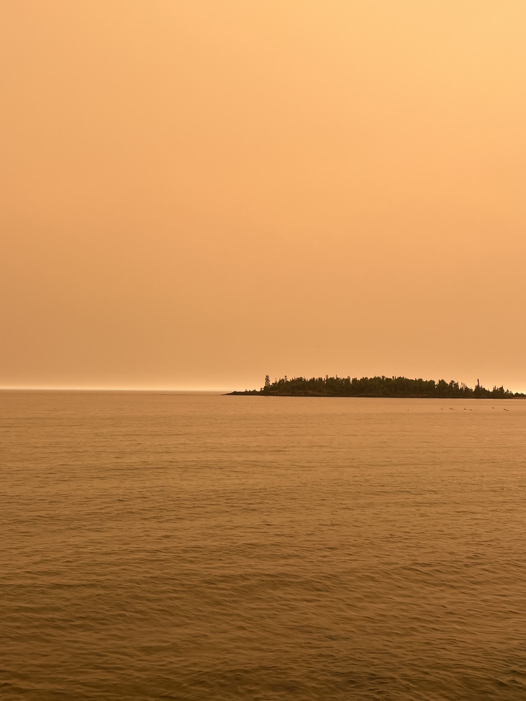 An orange, smoke-filled sky over Lake Superior as wildfire smoke moved into the Northland